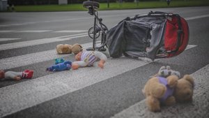 Przewrócony wózek dziecięcy i porozrzucane zabawki na przejściu dla pieszych