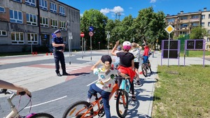 policjant ruchu drogowego w trakcie pogadanki z dziećmi na rowerowym  miasteczku